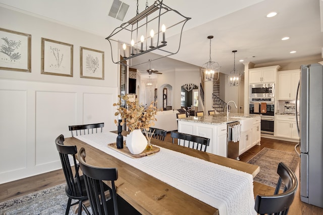 125 Magnolia Park Dr, Rossville, TN 38066 - dining space featuring a decorative wall, arched walkways, crown molding, dark wood finished floors, and recessed lighting