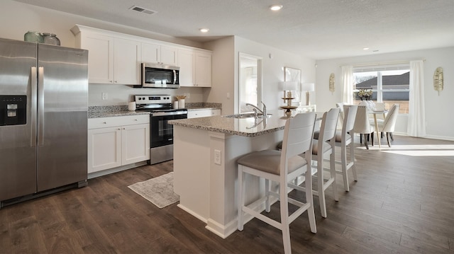 4494 Royster Creek Dr, Millington, TN 38053 - kitchen featuring stainless steel appliances, a sink, white cabinetry, an island with sink, and dark wood finished floors