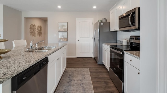 4494 Royster Creek Dr, Millington, TN 38053 - kitchen featuring appliances with stainless steel finishes, a sink, white cabinetry, dark wood-style flooring, and light stone countertops