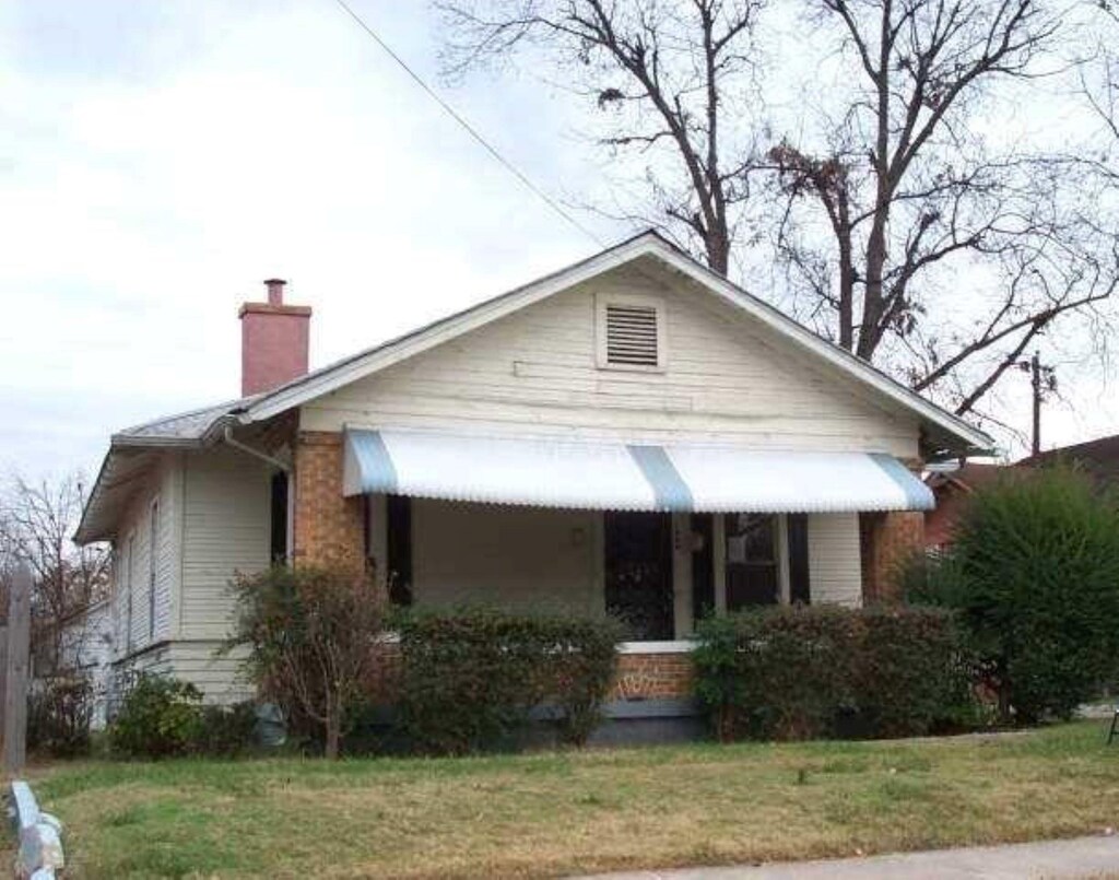 1404 Preston St, Memphis, TN 38106 - bungalow-style home with a chimney and a front yard