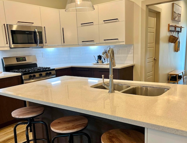 5510 Rams Horn Dr, Millington, TN 38053 - kitchen featuring appliances with stainless steel finishes, modern cabinets, light stone counters, and a kitchen breakfast bar