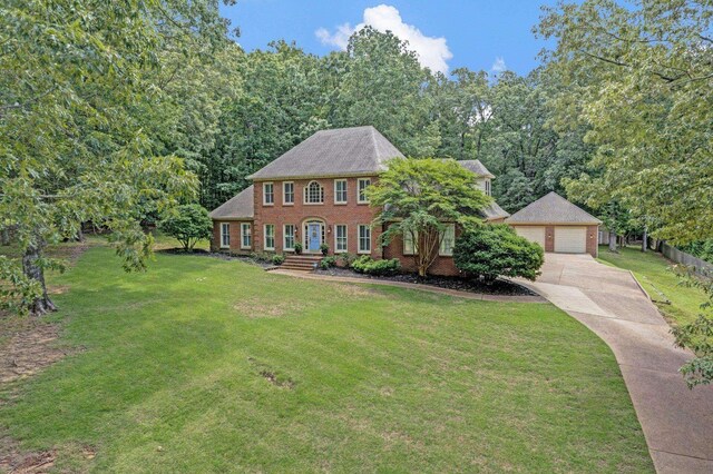 8955 Clair Douwie Cv, Bartlett, TN 38133 - colonial home with a detached garage, brick siding, a front yard, and an outbuilding