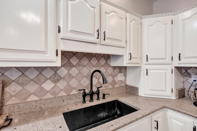 8955 Clair Douwie Cv, Bartlett, TN 38133 - kitchen with a sink, white cabinetry, decorative backsplash, and light stone counters