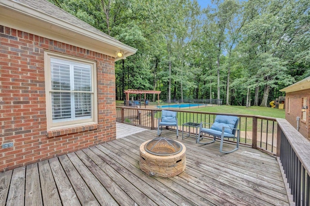 8955 Clair Douwie Cv, Bartlett, TN 38133 - wooden deck featuring a fire pit, an outdoor pool, a lawn, and view of wooded area