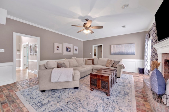 8955 Clair Douwie Cv, Bartlett, TN 38133 - living room featuring brick floors, ceiling fan, ornamental molding, a fireplace, and wainscoting