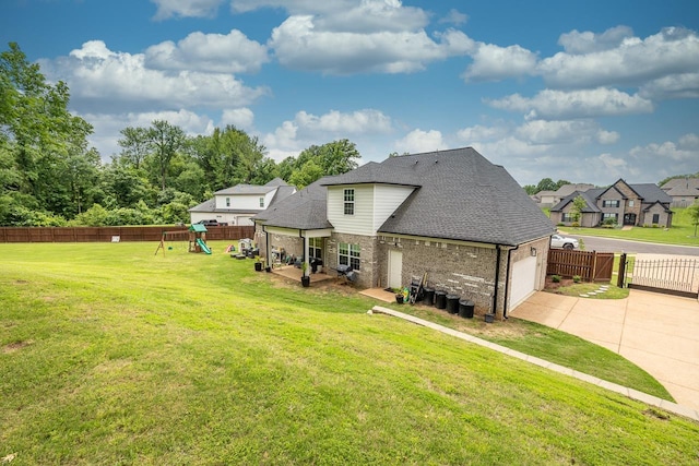128 Loch Haven Cv S, Atoka, TN 38004 - back of house with a playground, concrete driveway, an attached garage, brick siding, and a shingled roof