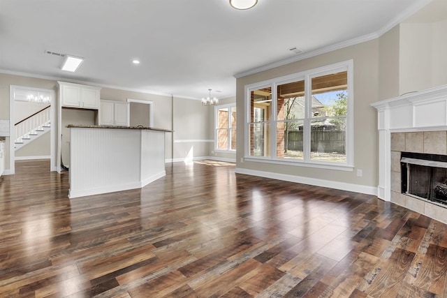 8917 River Sound Dr, Cordova, TN 38016 - unfurnished living room with a chandelier, crown molding, a fireplace, dark wood finished floors, and stairs