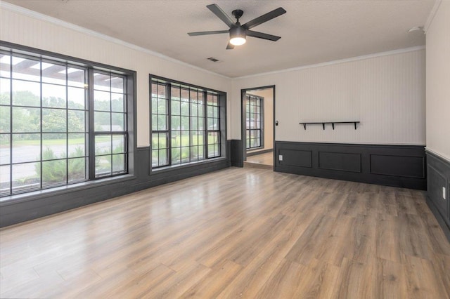 268 Tara Cv, Hernando, MS 38632 - unfurnished living room featuring ornamental molding, ceiling fan, wood finished floors, a decorative wall, and a wainscoted wall