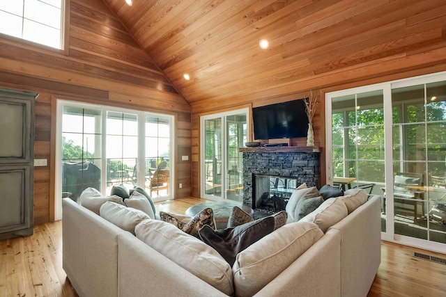 8 Shady Oak Cv, Iuka, MS 38852 - living area with wood ceiling, wood walls, a stone fireplace, light wood-style flooring, and high vaulted ceiling