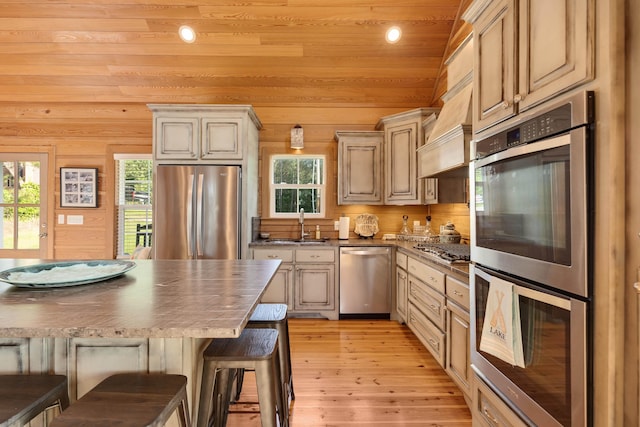 8 Shady Oak Cv, Iuka, MS 38852 - kitchen with appliances with stainless steel finishes, light wood-type flooring, dark countertops, a kitchen breakfast bar, and a sink