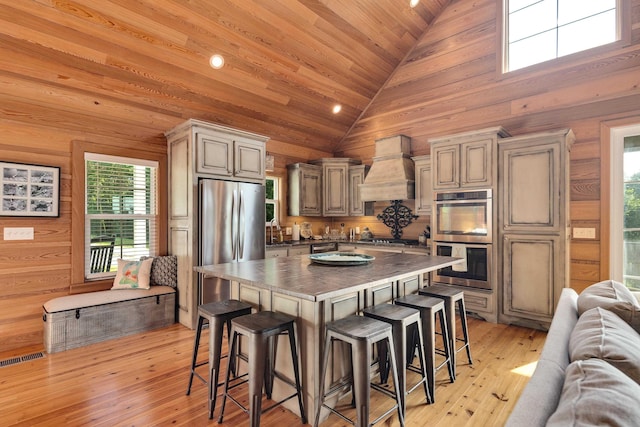 8 Shady Oak Cv, Iuka, MS 38852 - kitchen with custom exhaust hood, stainless steel appliances, open floor plan, a breakfast bar, and high vaulted ceiling