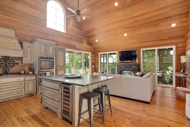 8 Shady Oak Cv, Iuka, MS 38852 - kitchen featuring beverage cooler, double oven, dark countertops, a breakfast bar area, and high vaulted ceiling