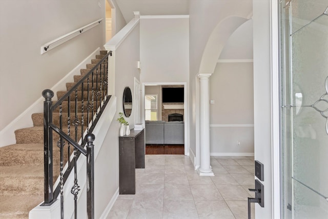 9071 E Tefall Cv, Cordova, TN 38016 - foyer featuring arched walkways, a fireplace, stairs, baseboards, and light tile patterned floors
