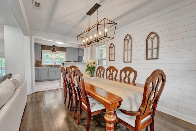 624 N Oak Grove Rd N, Memphis, TN 38120 - dining space with dark wood-style floors, a chandelier, and wooden walls
