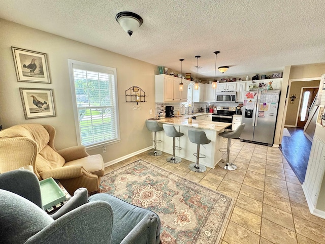 150 Westwood Cir, Ripley, TN 38063 - kitchen with appliances with stainless steel finishes, open floor plan, a peninsula, a kitchen breakfast bar, and tasteful backsplash