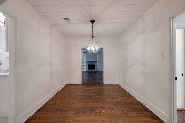 228 Palisade St, Memphis, TN 38111 - unfurnished dining area featuring dark wood-type flooring, a fireplace, baseboards, and a chandelier