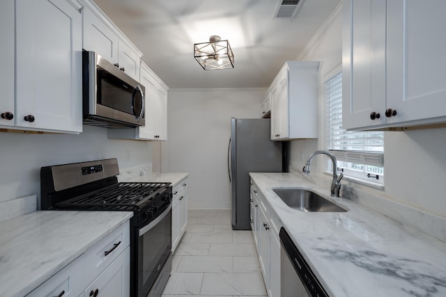 228 Palisade St, Memphis, TN 38111 - kitchen with stainless steel appliances, a sink, light marble finish flooring, white cabinets, and light stone countertops