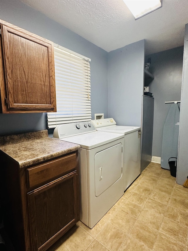 1145 Cypress Tank Rd, Pocahontas, TN 38061 - washroom with washer and clothes dryer, a textured ceiling, cabinet space, and light tile patterned flooring