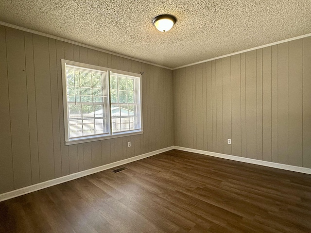 159 Hillhurst Dr, Selmer, TN 38375 - spare room featuring dark wood finished floors, a textured ceiling, wood walls, and crown molding