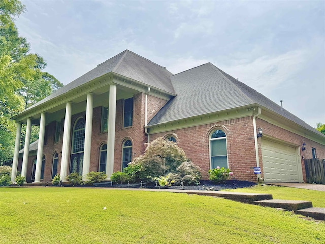 415 S Yates Cv, Memphis, TN 38120 - view of front of property featuring brick siding, a front yard, a shingled roof, and a garage