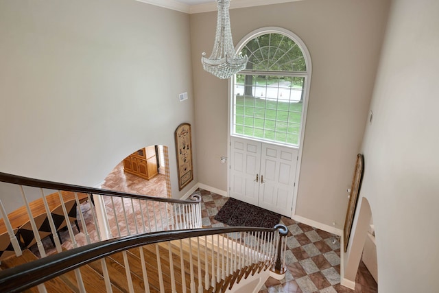 415 S Yates Cv, Memphis, TN 38120 - foyer entrance with a chandelier, baseboards, stairway, crown molding, and a high ceiling