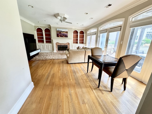 415 S Yates Cv, Memphis, TN 38120 - dining area with a premium fireplace, ceiling fan, built in features, light wood finished floors, and ornamental molding