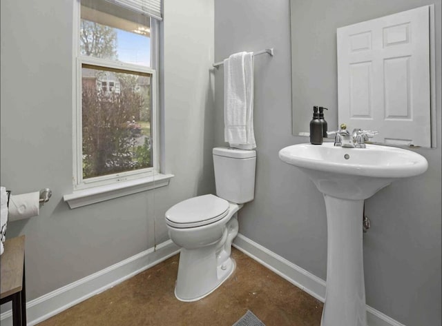 839 Woodlawn St, Memphis, TN 38107 - half bathroom featuring toilet, baseboards, and a sink