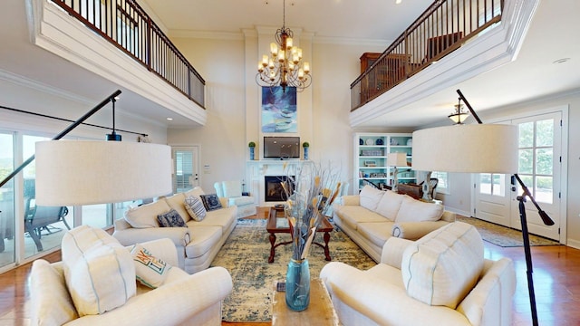 410 Shipwatch Pt, Savannah, TN 38372 - living area with wood finished floors, ornamental molding, a glass covered fireplace, a chandelier, and a towering ceiling