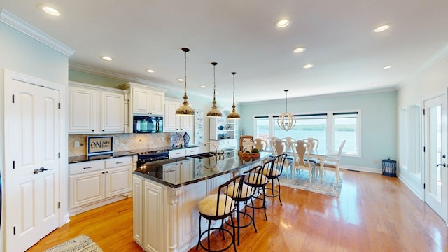 410 Shipwatch Pt, Savannah, TN 38372 - kitchen featuring black microwave, a sink, stainless steel electric stove, a kitchen bar, and dark countertops