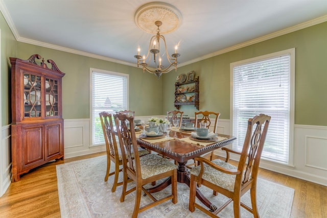 4834 Welchshire Ave, Memphis, TN 38117 - dining area with a chandelier, a wainscoted wall, light wood-type flooring, ornamental molding, and a decorative wall