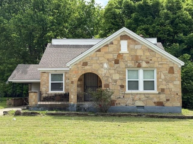 1838 Mcmillan Dr, Memphis, TN 38106 - tudor-style house featuring stone siding, a front yard, and roof with shingles