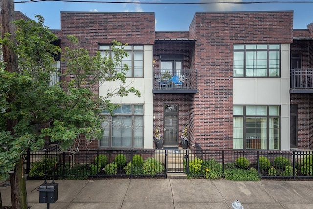 573 S Front St, Memphis, TN 38103 - view of front of house featuring brick siding, a fenced front yard, and a balcony