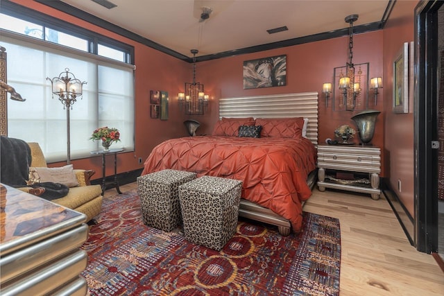 573 S Front St, Memphis, TN 38103 - bedroom featuring a chandelier, wood finished floors, baseboards, and crown molding