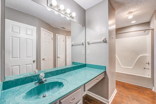 8023 Allbright Cv, Bartlett, TN 38133 - full bath featuring vanity, washtub / shower combination, wood finished floors, a textured ceiling, and baseboards