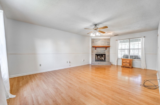8023 Allbright Cv, Bartlett, TN 38133 - unfurnished living room featuring a textured ceiling, light wood-style floors, ceiling fan, a fireplace, and baseboards