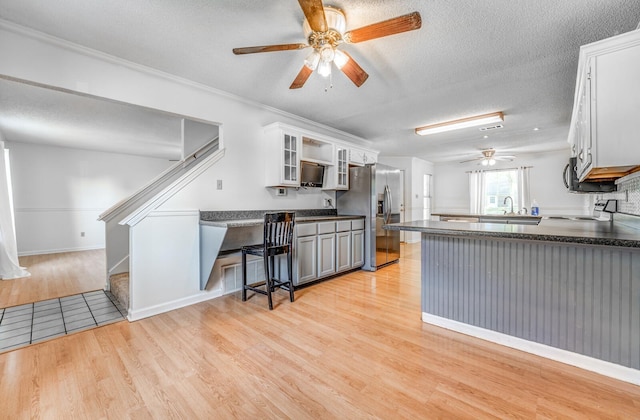8023 Allbright Cv, Bartlett, TN 38133 - kitchen with appliances with stainless steel finishes, a ceiling fan, light wood-type flooring, dark countertops, and a peninsula