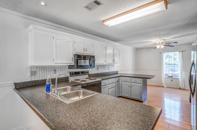 8023 Allbright Cv, Bartlett, TN 38133 - kitchen featuring range with electric stovetop, a peninsula, black microwave, dark countertops, and a textured ceiling