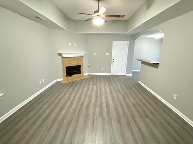 7407 Crayton Ridge Dr, Cordova, TN 38018 - unfurnished living room with baseboards, a ceiling fan, a tile fireplace, and arched walkways