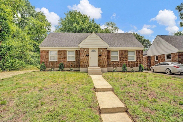 1394 Chadwick Cir, Memphis, TN 38114 - view of front of house with a front lawn, brick siding, and roof with shingles