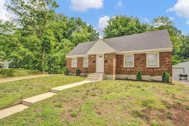 1394 Chadwick Cir, Memphis, TN 38114 - view of front of home featuring brick siding, a front lawn, roof with shingles, and an outdoor structure