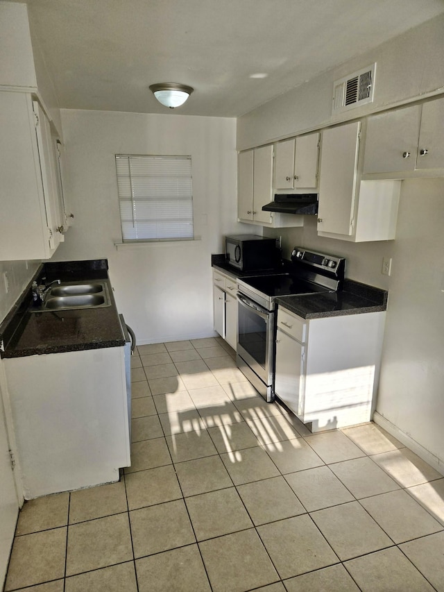 3393 Brownbark Dr, Memphis, TN 38115 - kitchen with stainless steel range with electric stovetop, black microwave, dark countertops, white cabinetry, and light tile patterned floors