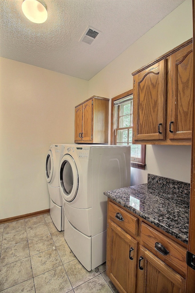 791 Autumn Winds Dr, Collierville, TN 38017 - laundry area with cabinet space, washing machine and clothes dryer, a textured ceiling, baseboards, and light tile patterned floors