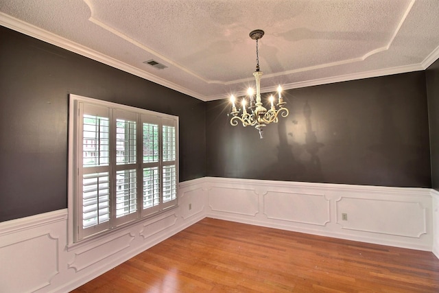 791 Autumn Winds Dr, Collierville, TN 38017 - unfurnished room featuring a textured ceiling, a chandelier, a wainscoted wall, wood finished floors, and crown molding