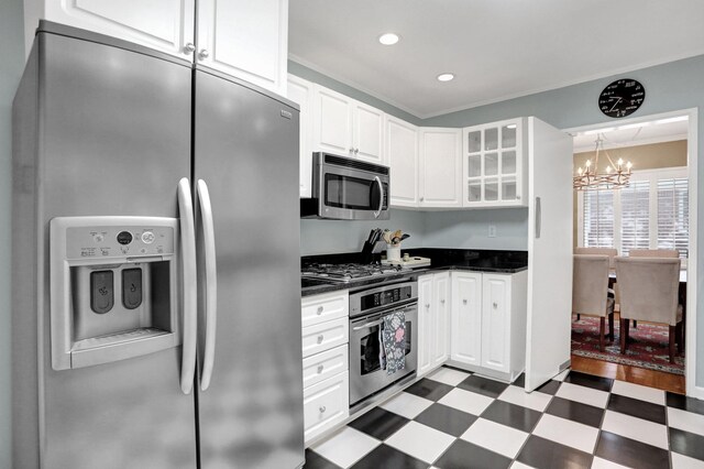 4141 Sequoia Ave, Memphis, TN 38117 - kitchen featuring stainless steel appliances, a chandelier, dark flooring, white cabinets, and crown molding
