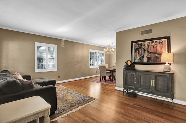 4141 Sequoia Ave, Memphis, TN 38117 - living area with a chandelier, crown molding, wood finished floors, and baseboards