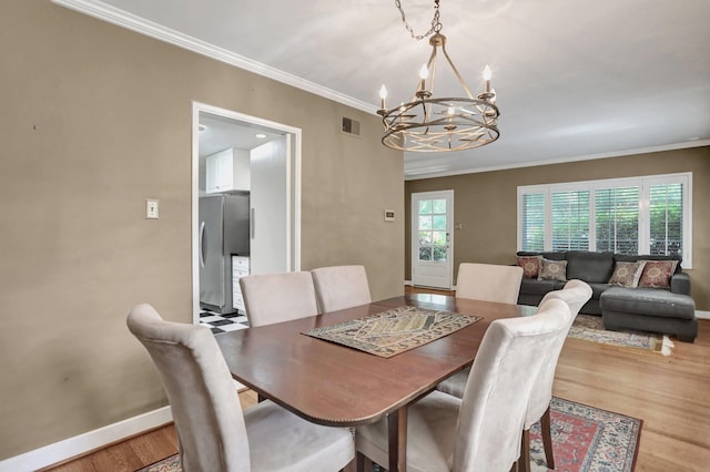 4141 Sequoia Ave, Memphis, TN 38117 - dining area with a chandelier, wood finished floors, baseboards, and ornamental molding