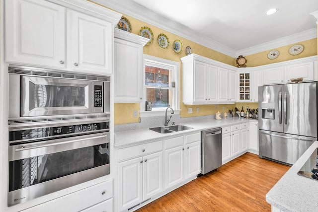 182 Harbor Isle Cir, Memphis, TN 38103 - kitchen with stainless steel appliances, a sink, white cabinetry, glass insert cabinets, and crown molding