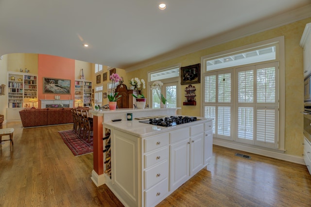 182 Harbor Isle Cir, Memphis, TN 38103 - kitchen with black gas cooktop, light countertops, wood finished floors, crown molding, and a fireplace