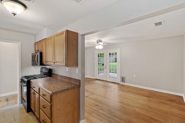 307 Melita Rd, Memphis, TN 38120 - kitchen featuring black range with gas cooktop, stainless steel microwave, a ceiling fan, baseboards, and dark countertops