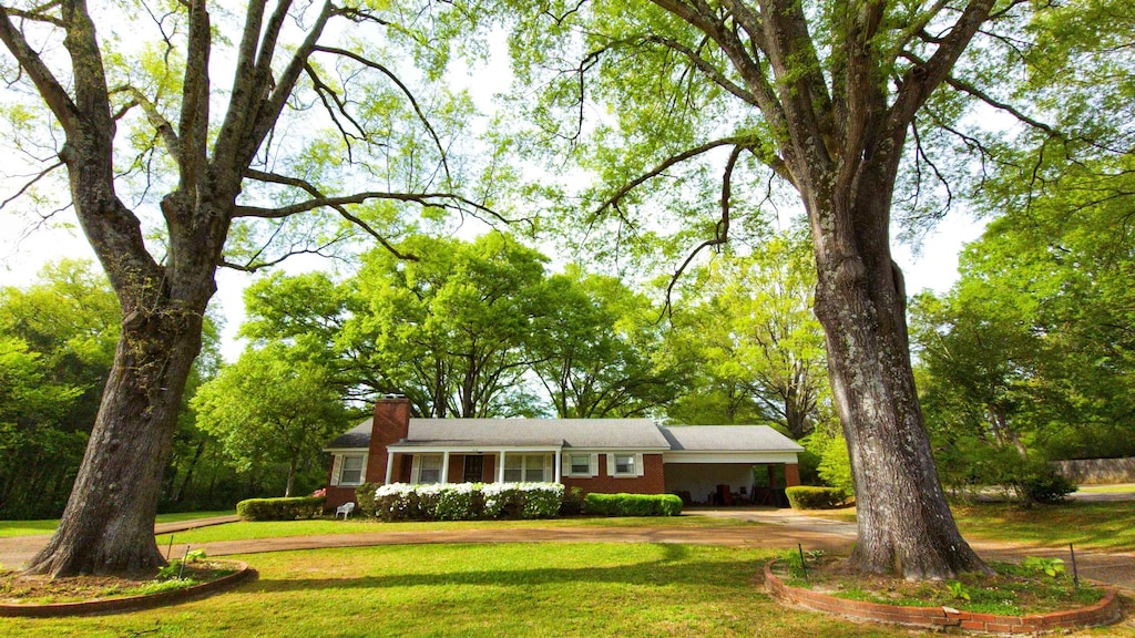 318 W Poplar Ave, Collierville, TN 38017 - single story home with curved driveway, a chimney, a front lawn, and a carport